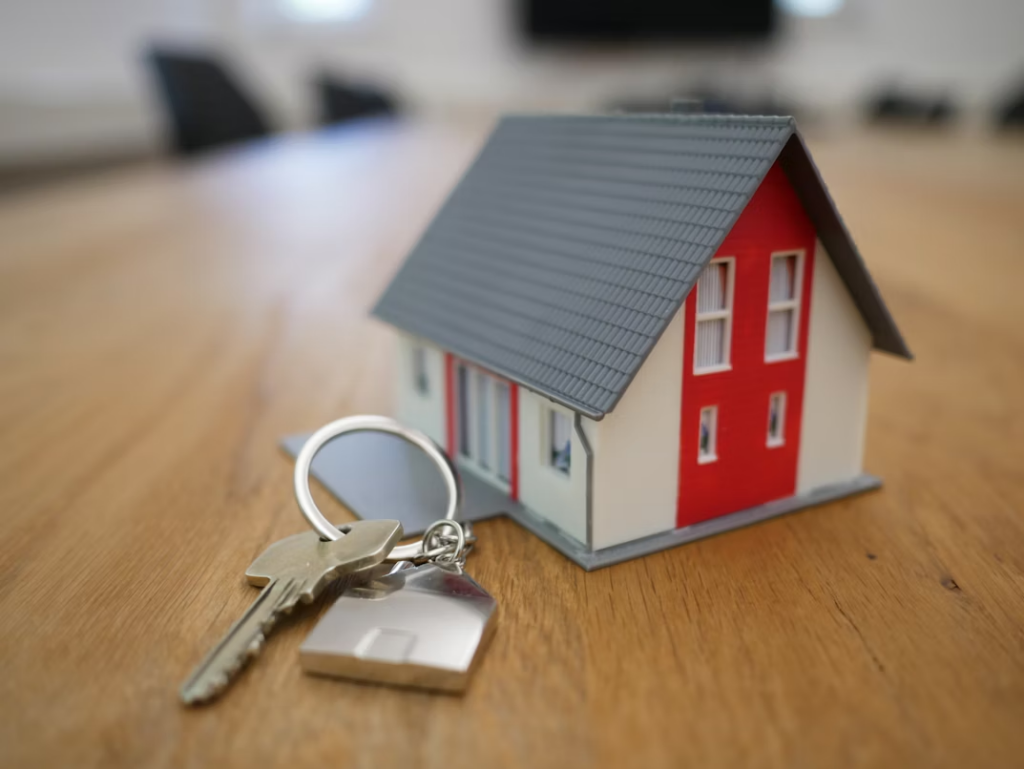White and red wooden miniature house on a wooden table. 